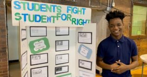 Alain Locke student stands in front of his submission to the 2020 History Fair